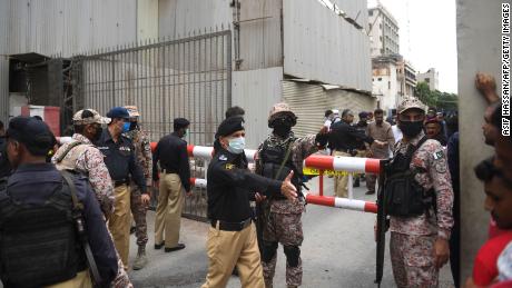 Personel keamanan berkumpul di pintu masuk utama gedung Bursa Efek Pakistan di Karachi pada 29 Juni 2020.