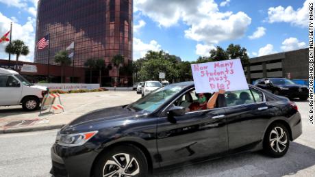 Para guru memprotes di luar markas Sekolah Umum Orange County Florida pada hari Selasa.