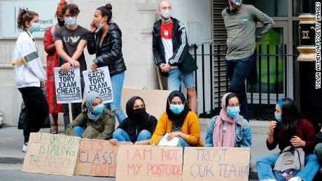 Para siswa memegang plakat saat mereka melakukan protes di luar Departemen Pendidikan di pusat kota London pada 14 Agustus.