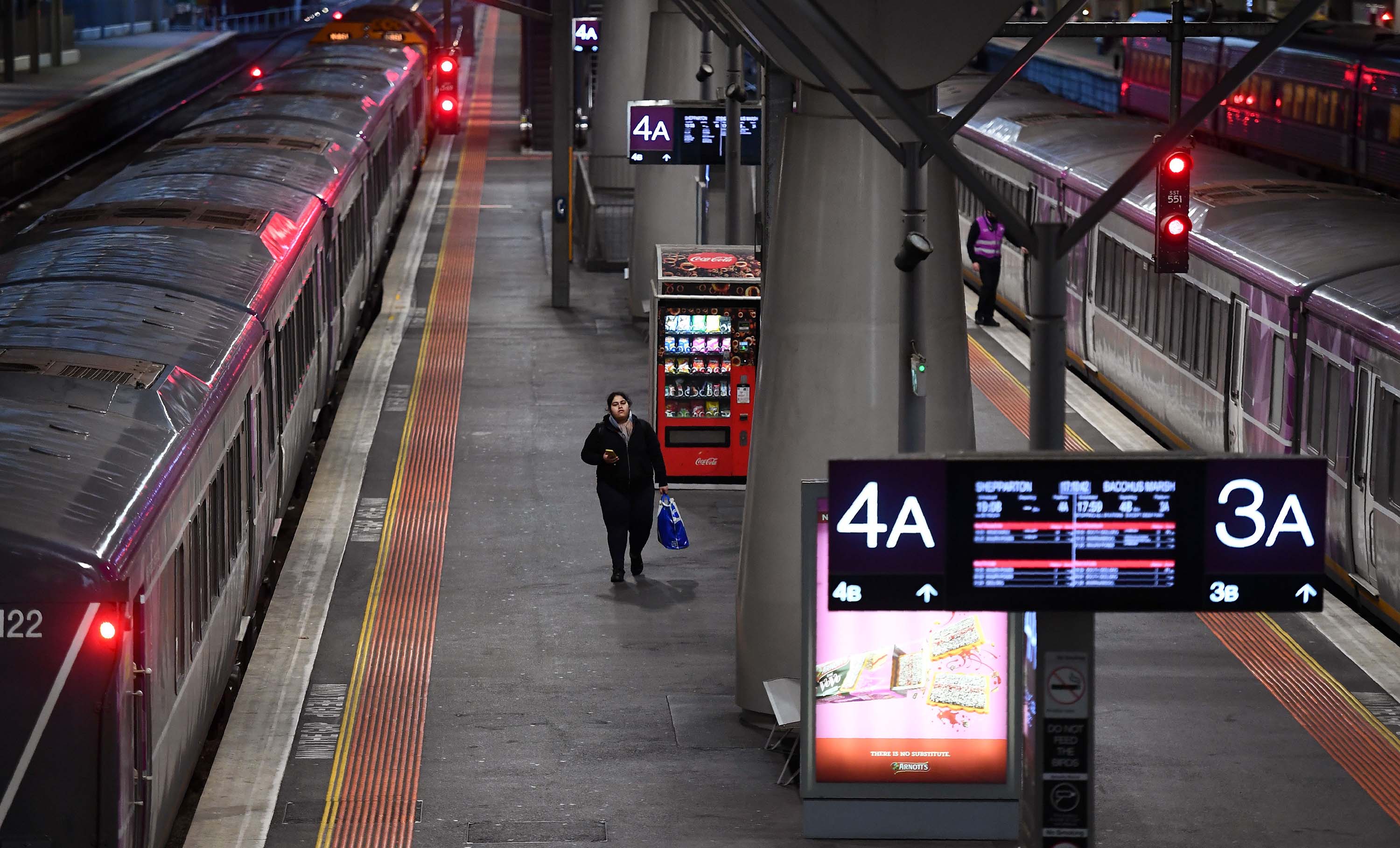 Seorang penumpang berjalan di sepanjang peron selama jam sibuk di stasiun Southern Cross Melbourne pada 30 Juni. Negara bagian Victoria di Australia telah memperkenalkan kembali tindakan penguncian di 10 pinggiran kota Melbourne menyusul lonjakan baru-baru ini dalam kasus coronavirus.