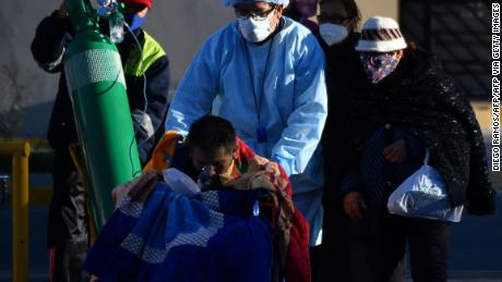 Seorang perawat membantu seorang pasien Covid-19 di luar rumah sakit di kota Arequipa, Peru, pada 23 Juli 2020.