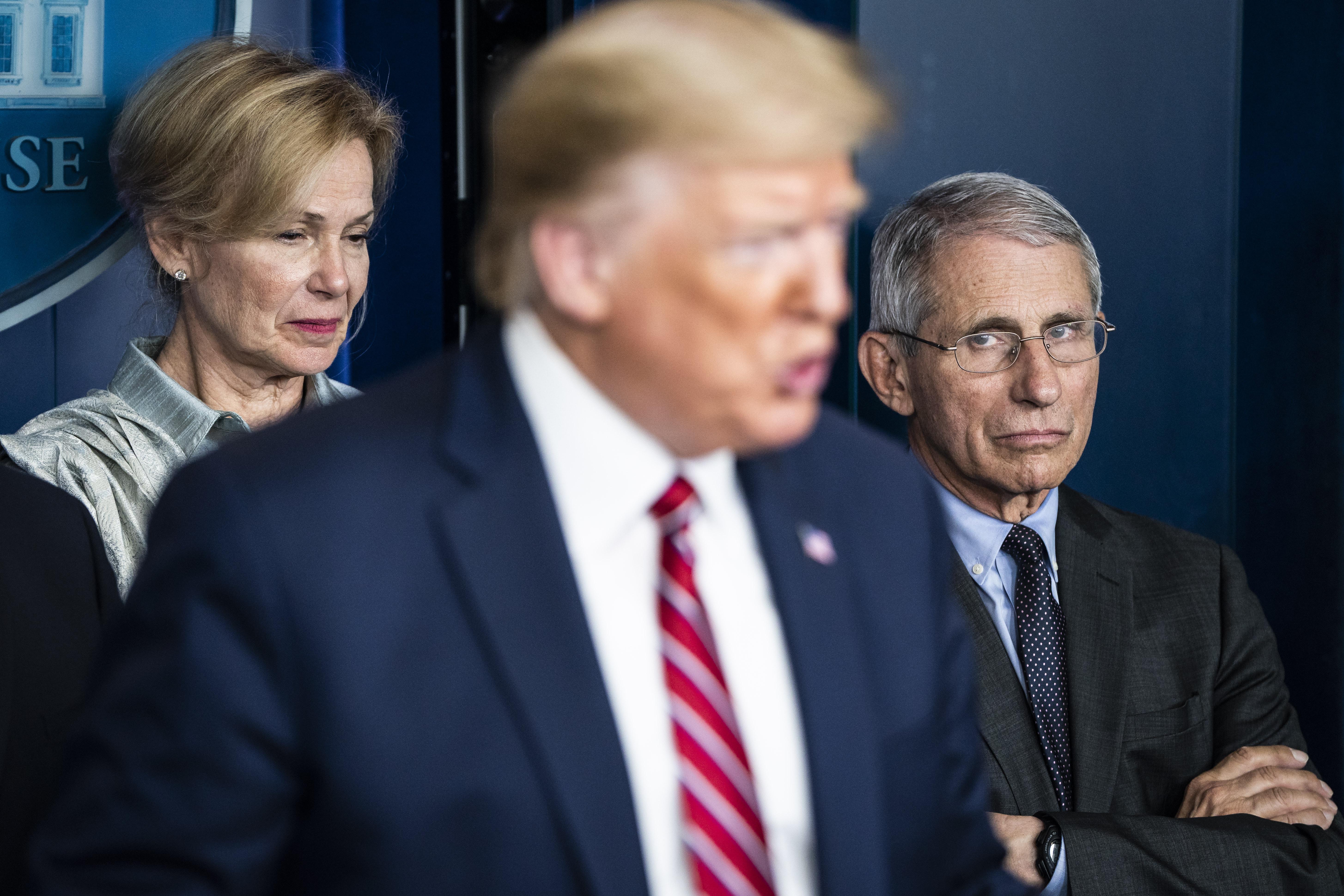 Dari kiri di latar belakang, Dr. Deborah Birx dan Dr. Anthony Fauci mendengarkan ketika Presiden Donald Trump berbicara pada pengarahan coronavirus di Washington, DC, pada 20 Maret.