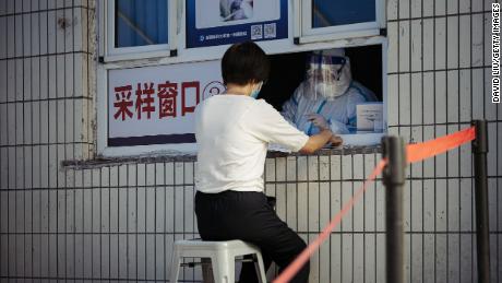 Seorang wanita menerima tes asam nukleat Covid-19 di Rumah Sakit Afiliasi Pertama Universitas Kedokteran Xinjiang pada 25 Juni di Urumqi, Cina.