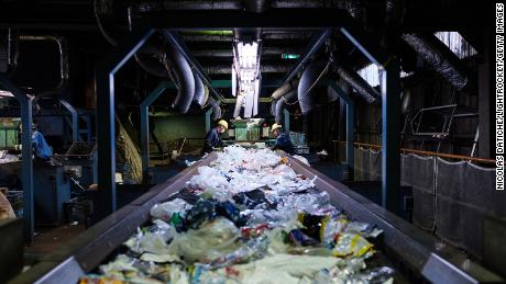 Para pekerja memilah sampah plastik sekali pakai pada sebuah conveyor di pusat daur ulang Teknik Ichikawa Kankyo. Kantor kota Katsushika di Tokyo membawa sekitar 10 ton sumber daya plastik daur ulang setiap hari ke fasilitas daur ulang.