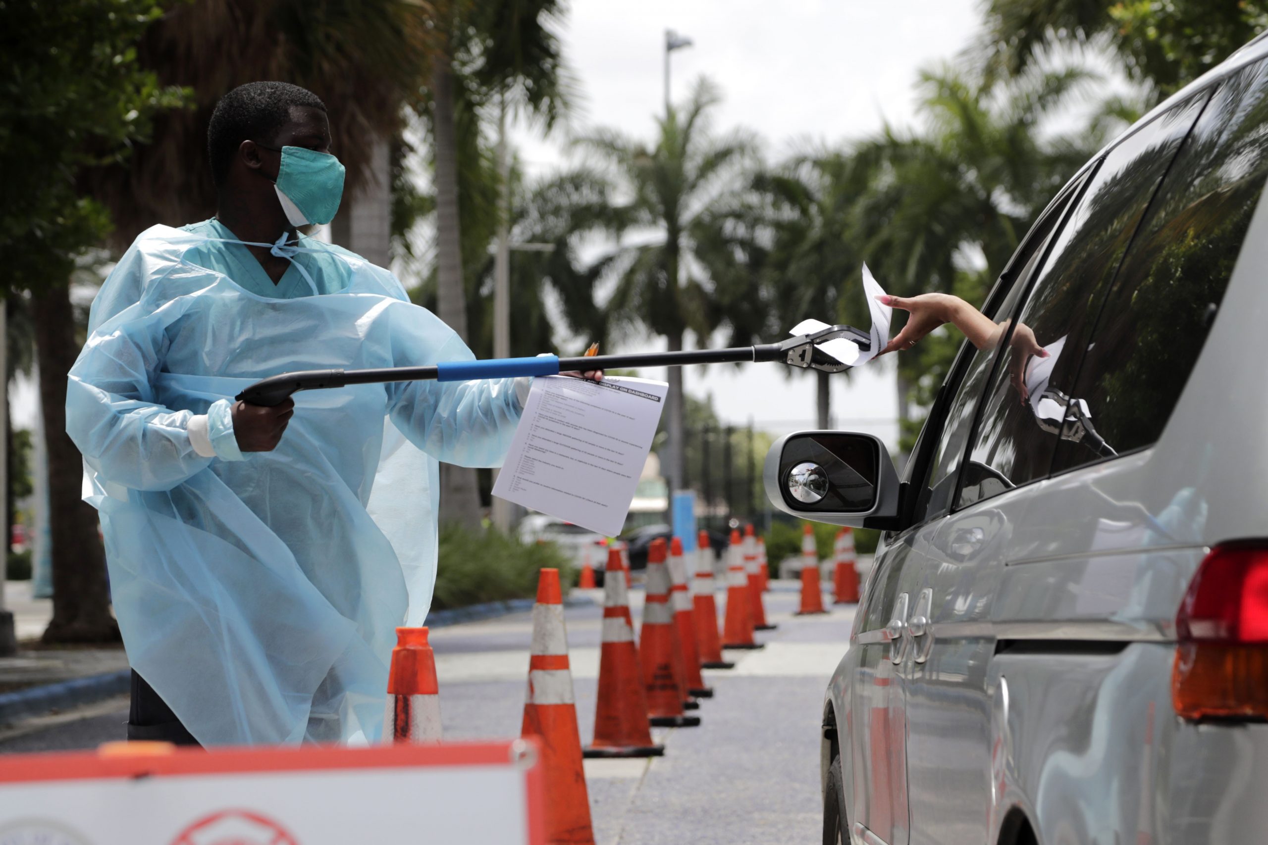 A health care worker passes paperwork to someone at a Covid-19 testing site in Miami on July 27.